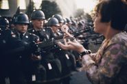 17-year-old Jan Rose Kasmir offers a flower to soldiers during the Pentagon anti-war protest in 1967.