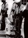 The child of a KKK member touches his reflection in an African American police officer’s riot shield during a demonst...