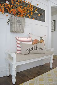 A small fall farmhouse entryway with a vintage white bench