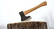 An image of an axe on a tree stump.