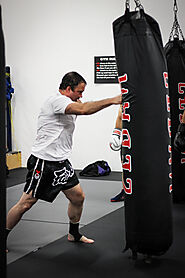 Kickboxing class hiting a heavy bag. Photo credit: Evolution MMA Chicago