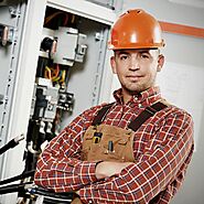 electrical contractor standing in front of an electrical cabinet