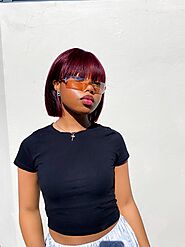 Black girl wearing reddish purple bob wig under the sun and show the different vibe