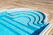 Transform your backyard with this fiberglass pool kit, featuring elegant curved steps and a seamless wooden deck.