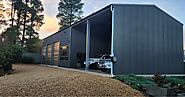 A modern building with cars parked in the garage, featuring high-quality carports Adelaide for protection and style.