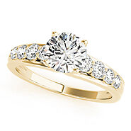 Yellow gold Round Brilliant Solitaire with Side Stones on a Pave Band and Four-Prong Setting