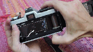 With Finger on Rotator and Thumb on Bottom Button, Crank the film
